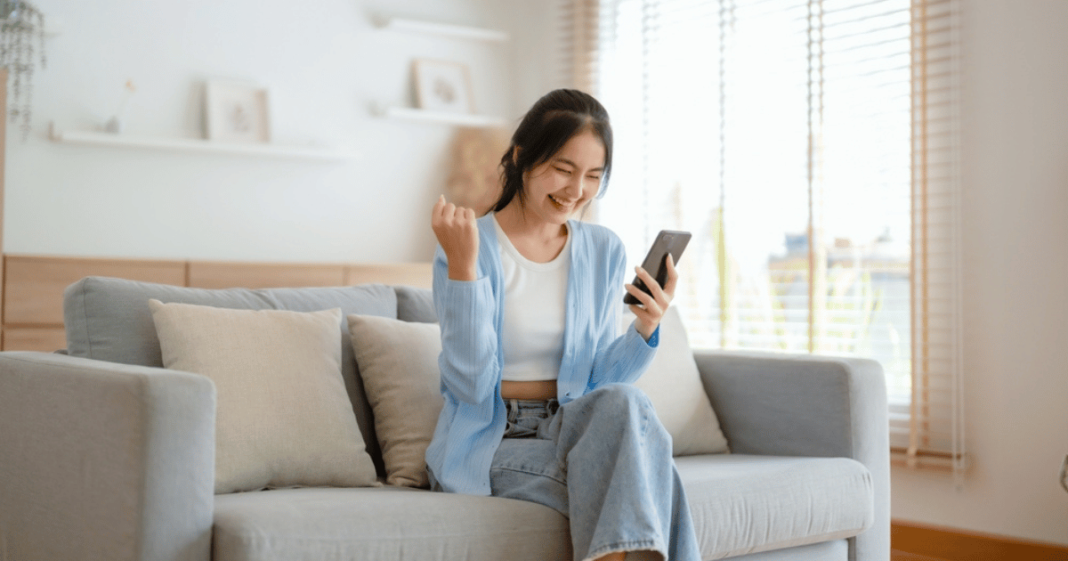 Asian Woman Looking at Phone Laughing