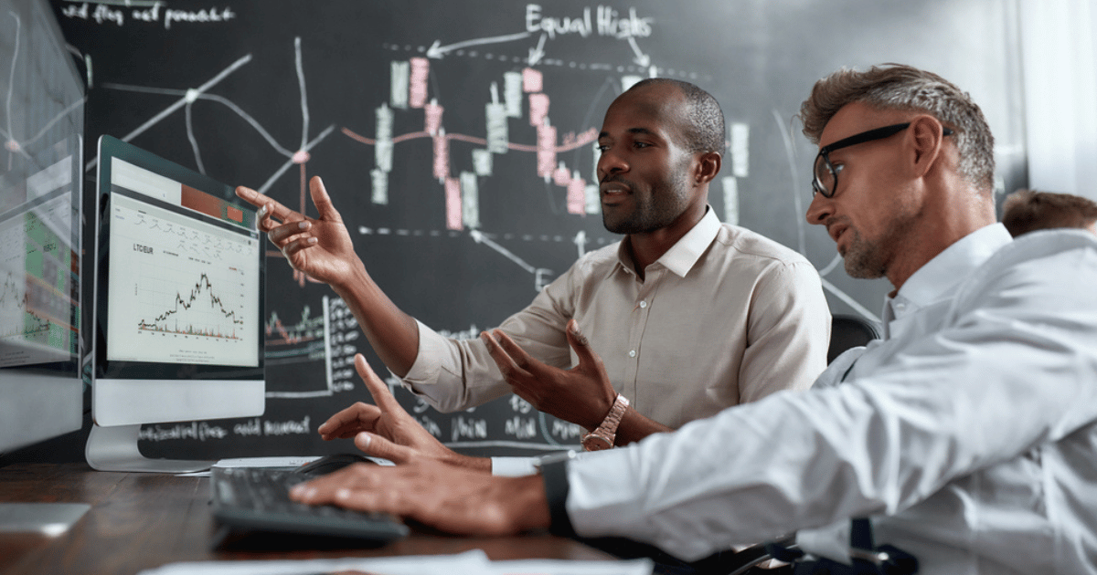 Two Men Looking at Stocks on Screens