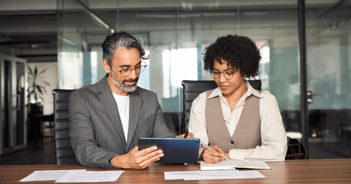 Two People Looking at Tablet Discussing Finances