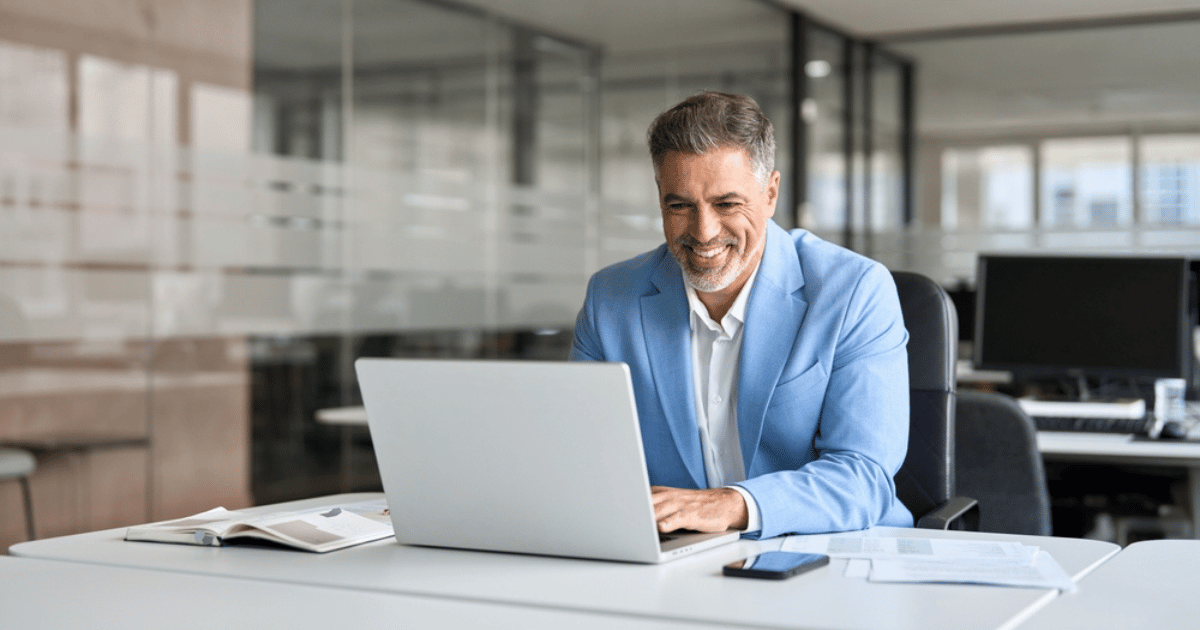 Man Blue Suit Laptop Desk Smiling